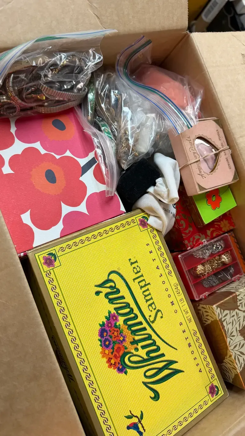 Open basement box filled with vintage jewelry boxes, bagged jewelry and assorted pieces brought to Warren Exchange.