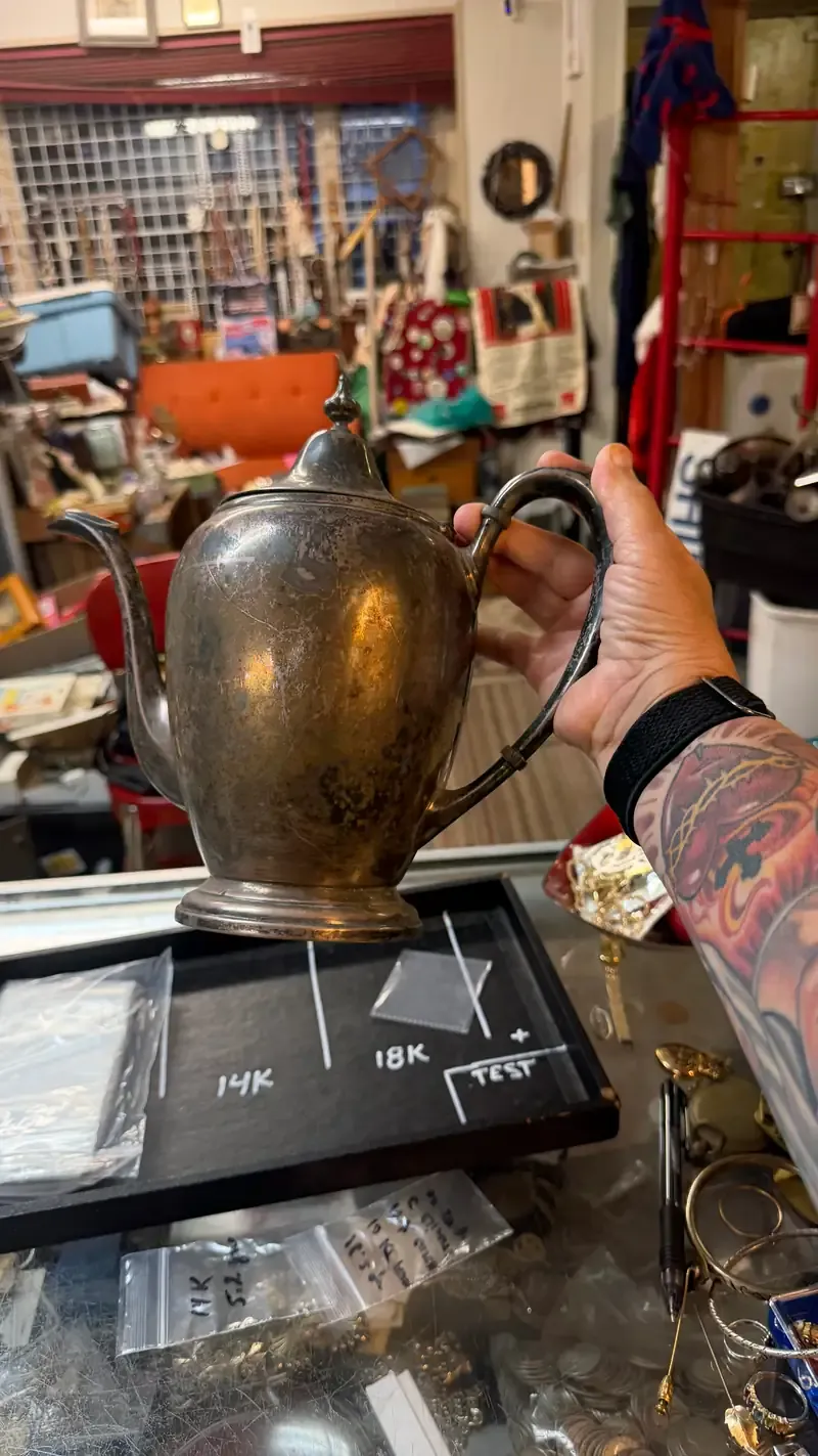 Warren Exchange examining an estate teapot for silver content.